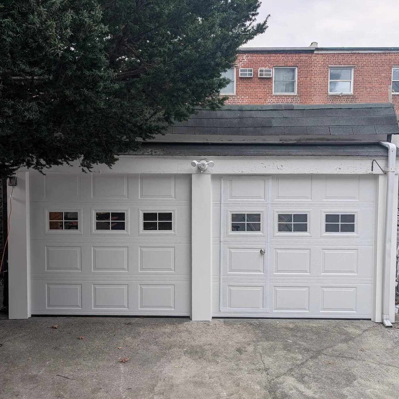 New white double garage doors installed for a homeowner in Queens, NY