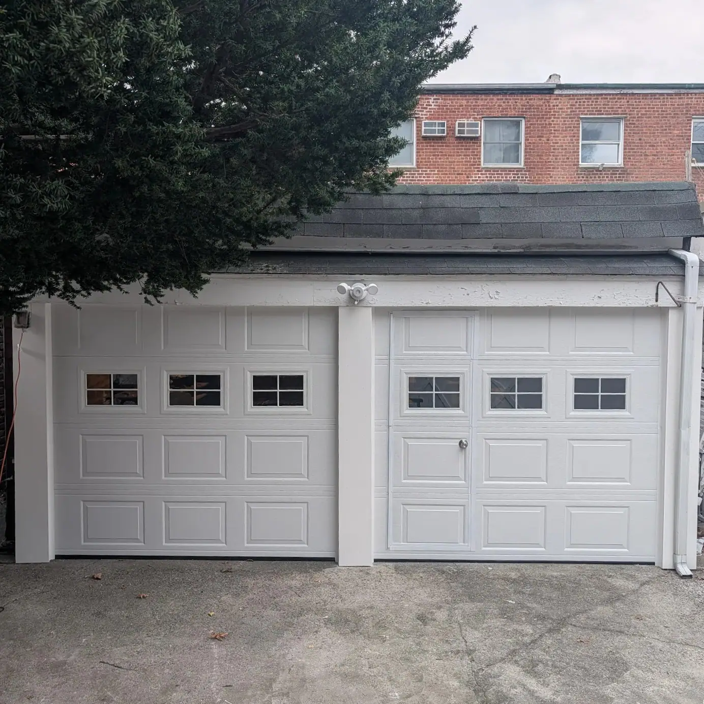 New white double garage doors installed for a homeowner in Queens, NY